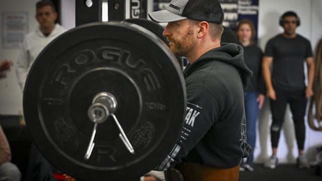 A competitor preparing to squat a loaded barbell