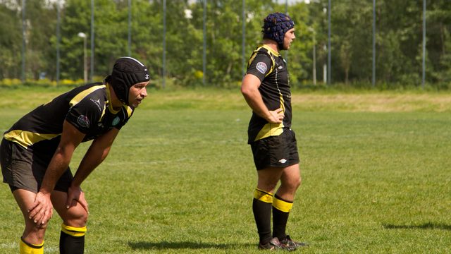 Rugby players wearing protective scrum caps during play